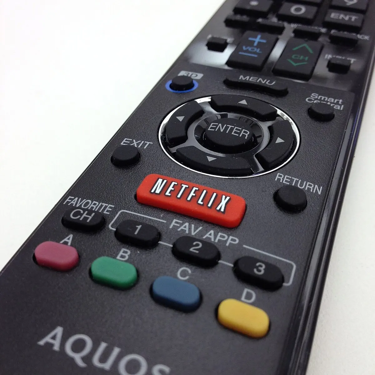 Remote TV Sharp Aquos berwarna hitam dengan tombol merah bertulisan NETFLIX di bawah tombol navigasi ENTER