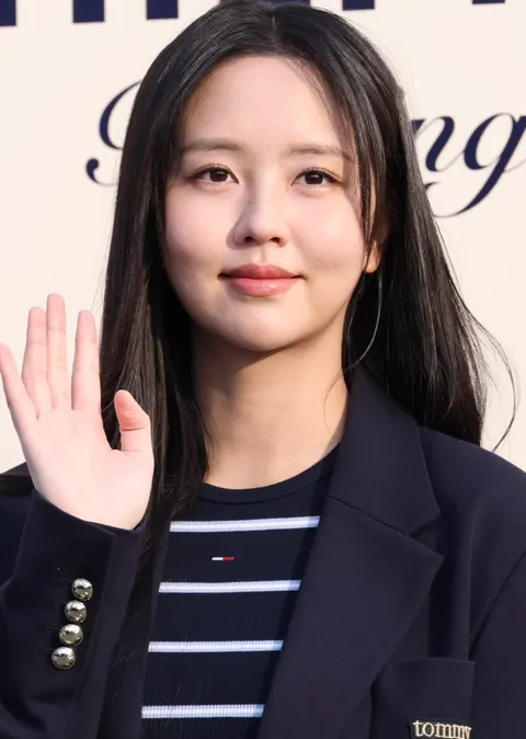 Kim So-hyun berambut panjang dan berblazer biru tua melambaikan tangan