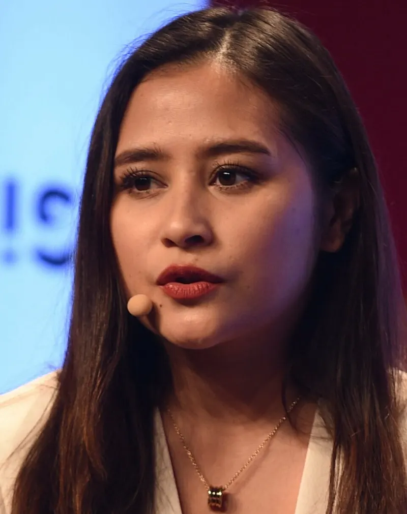 Prilly Latuconsina berbicara dengan mikrofon kepala di atas panggung konferensi