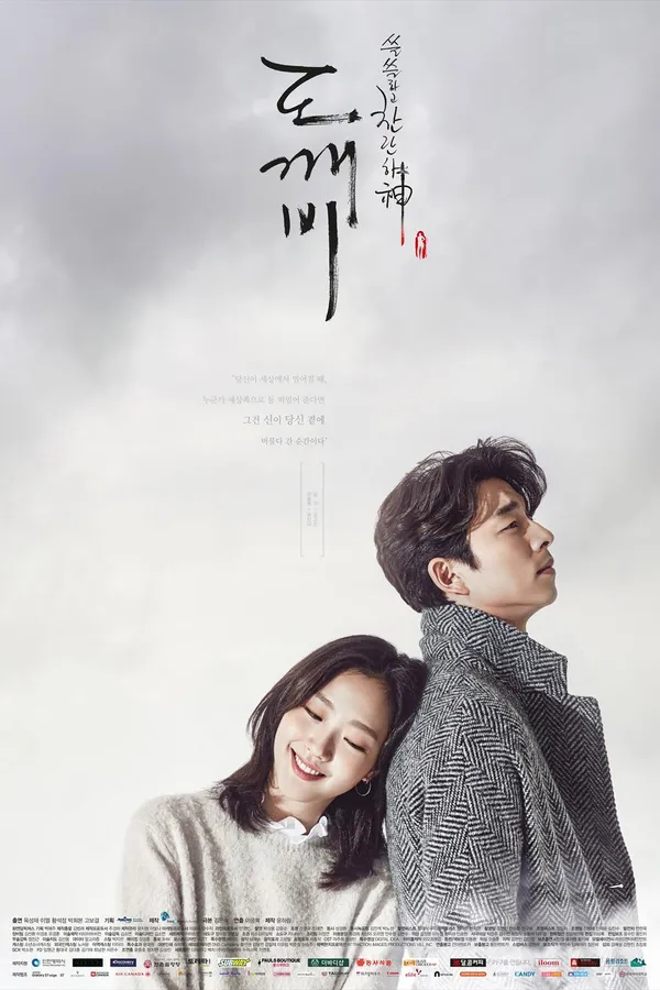 Poster resmi Goblin (2016): Kim Go-eun tersenyum bersandar di punggung Gong Yoo yang bermantel abu-abu, di bawah langit mendung dengan judul kaligrafi Korea 도깨비