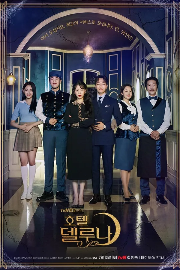Poster resmi Hotel Del Luna (2019): IU bergaun hitam dan Yeo Jin-goo berjas biru tua berdiri di tengah para staf hotel di lobi bergaya klasik, dengan judul Korea 호텔 델루나 berhias bulan sabit emas