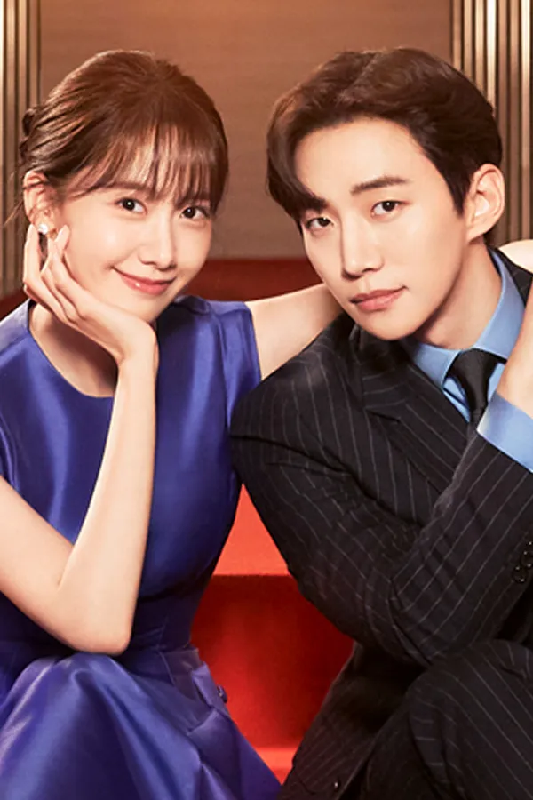 Gambar utama resmi King the Land (2023) dari JTBC, dipotong ke format potret: Lim Yoon-a bergaun biru dan Lee Jun-ho bersetelan garis duduk berdampingan di tangga berkarpet merah