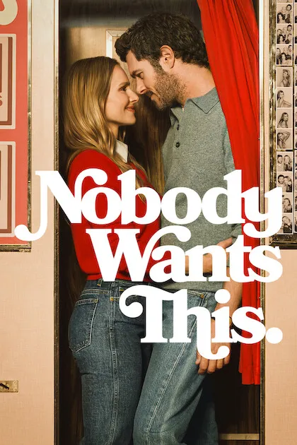 Poster resmi Nobody Wants This (2024): Kristen Bell bersweter merah dan Adam Brody saling mendekat di depan bilik foto bertirai merah, judul berhuruf putih melengkung.